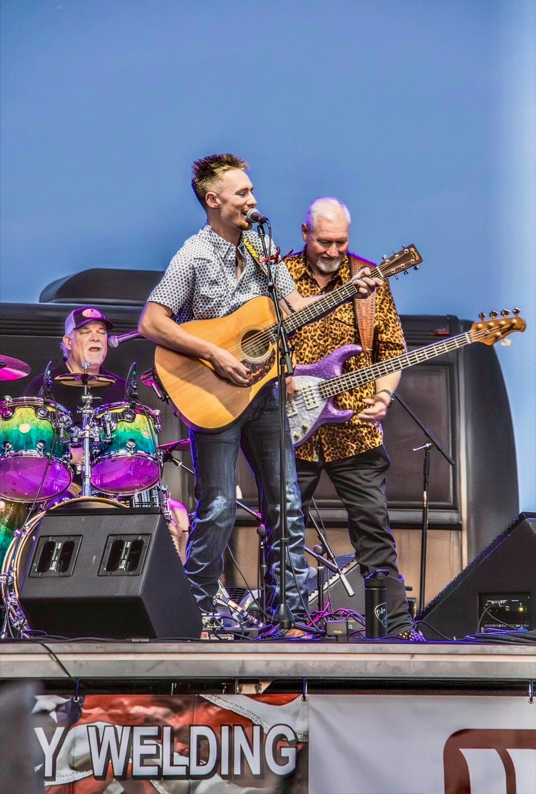 Dillon Leggett performing with his band under purple stage lights